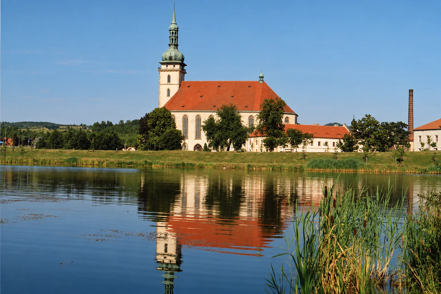 Kostel Nanebevzetí Panny Marie v Mostě s odrazem ve vodě